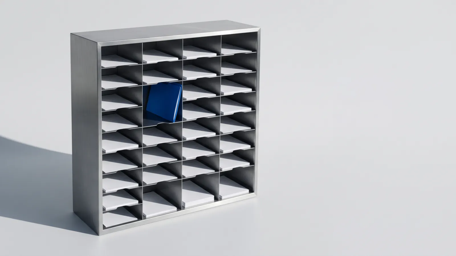A steel sorting rack with blank sheets filed in its pigeonholes and one blue folder.